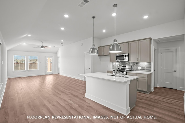975 Oak Mist Ln, Magnolia, TX 77354 - kitchen featuring gray cabinets, stainless steel microwave, light countertops, recessed lighting, and decorative backsplash