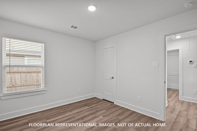 975 Oak Mist Ln, Magnolia, TX 77354 - unfurnished bedroom with wood finished floors, baseboards, and attic access
