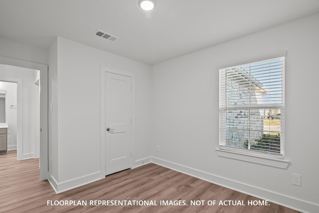 975 Oak Mist Ln, Magnolia, TX 77354 - spare room featuring baseboards, light wood-style floors, and healthy amount of natural light