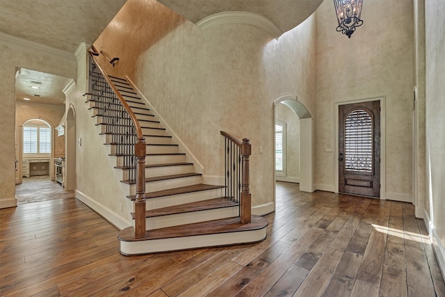 61 Parkgate, Shenandoah, TX 77381 - foyer entrance featuring arched walkways, wood-type flooring, baseboards, stairs, and ornamental molding