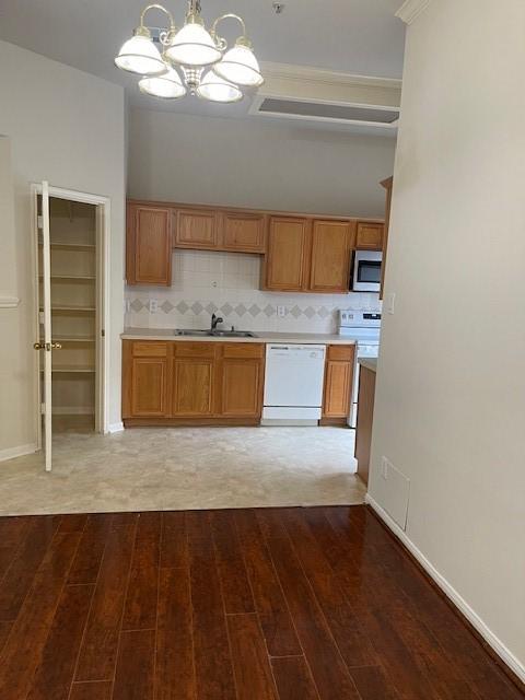 2710 Grants Lake Blvd Unit S4, Sugar Land, TX 77479 - kitchen with white appliances, wood finished floors, a sink, and a chandelier