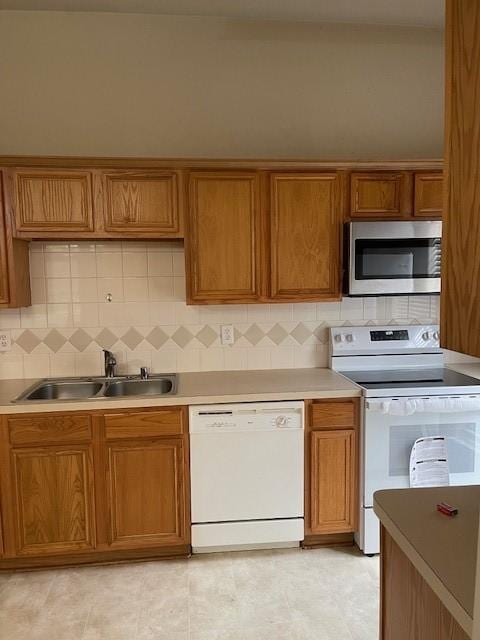 2710 Grants Lake Blvd Unit S4, Sugar Land, TX 77479 - kitchen featuring white appliances, a sink, brown cabinets, and decorative backsplash