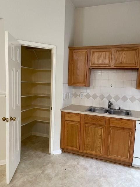 2710 Grants Lake Blvd Unit S4, Sugar Land, TX 77479 - kitchen with brown cabinetry, a sink, tasteful backsplash, and light countertops