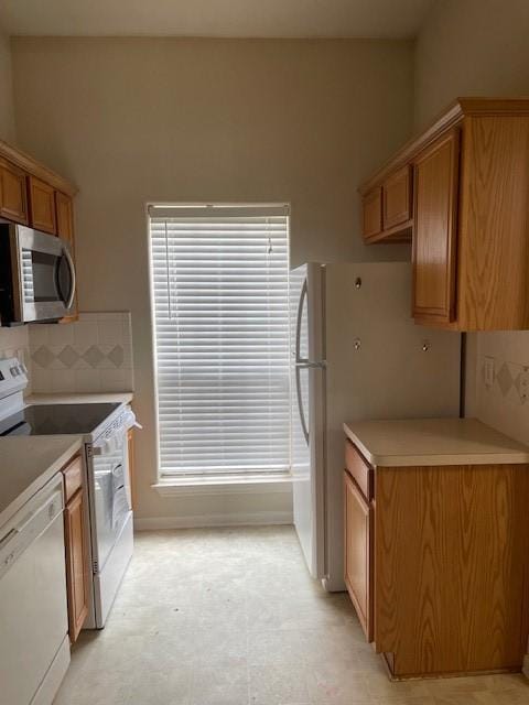 2710 Grants Lake Blvd Unit S4, Sugar Land, TX 77479 - kitchen with white appliances, brown cabinetry, plenty of natural light, and light countertops