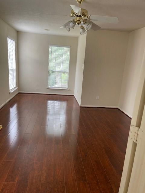 2710 Grants Lake Blvd Unit S4, Sugar Land, TX 77479 - empty room with dark wood-style floors, ceiling fan, and baseboards