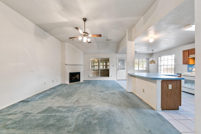 7110 Pine Bower Ct, Humble, TX 77346 - kitchen featuring electric stove, a ceiling fan, a fireplace with flush hearth, a peninsula, and brown cabinets