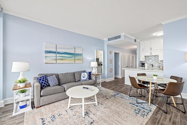 1401 E Beach Dr Unit 1205, Galveston, TX 77550 - living area featuring crown molding, wood finished floors, and baseboards