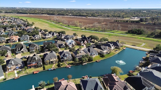 aerial view of property and surrounding area featuring nearby suburban area and a nearby body of water
