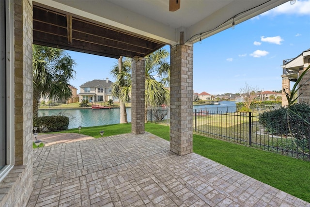 view of patio with a water view, a residential view, and ceiling fan