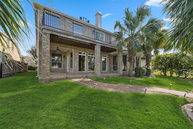 back of property featuring ceiling fan, brick siding, and a balcony