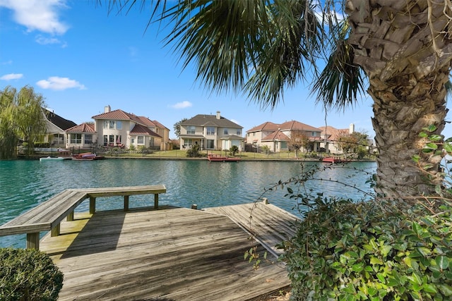 dock with a residential view and a water view