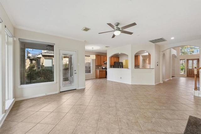 unfurnished living room with ceiling fan, arched walkways, light tile patterned flooring, baseboards, and recessed lighting