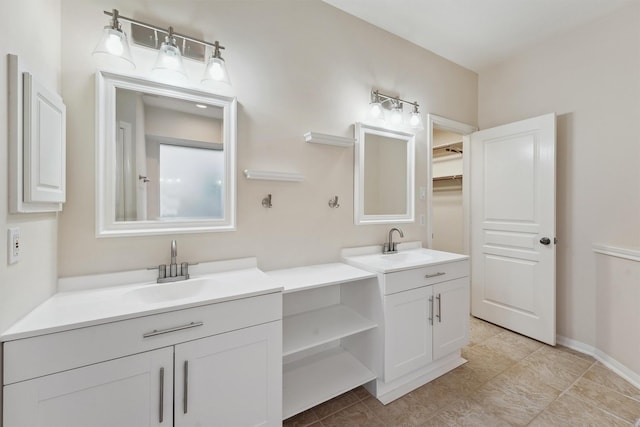 bathroom with two vanities, a walk in closet, and tile patterned floors