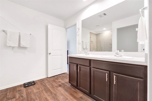 21614 Gusto Glen Ln, Katy, TX 77449 - full bathroom with a shower stall, double vanity, wood finished floors, and baseboards