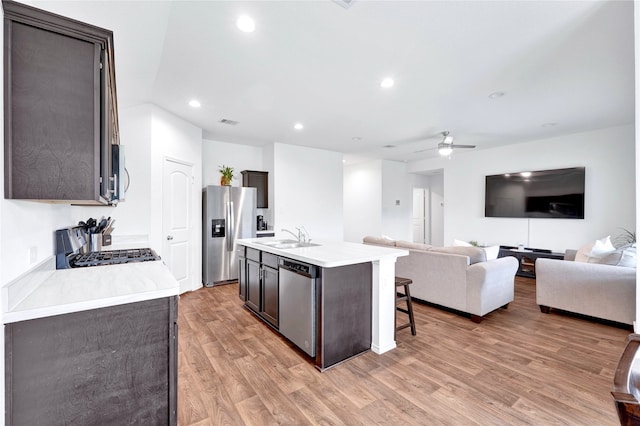 21614 Gusto Glen Ln, Katy, TX 77449 - kitchen with stainless steel appliances, ceiling fan, light countertops, light wood-type flooring, and open floor plan