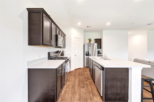 21614 Gusto Glen Ln, Katy, TX 77449 - kitchen featuring appliances with stainless steel finishes, a sink, dark brown cabinetry, light countertops, and recessed lighting