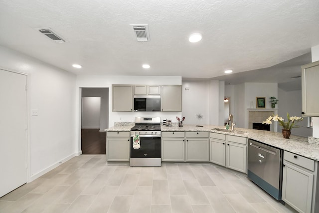9223 Eaglewood Glen Trl, Houston, TX 77083 - kitchen with stainless steel appliances, a sink, gray cabinets, recessed lighting, and light stone counters