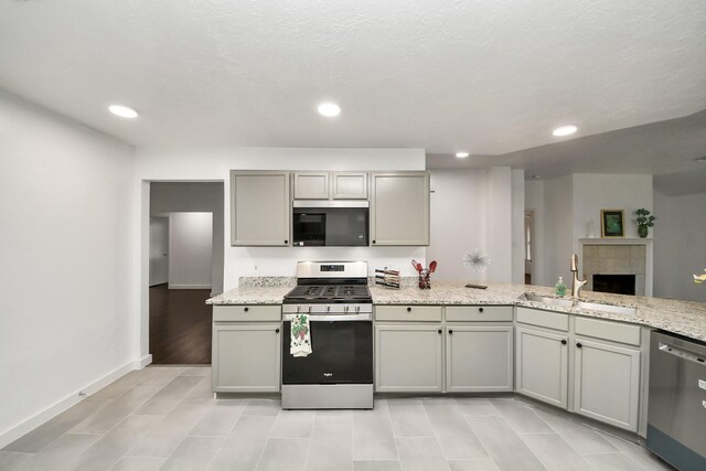 9223 Eaglewood Glen Trl, Houston, TX 77083 - kitchen with appliances with stainless steel finishes, a sink, gray cabinetry, recessed lighting, and baseboards