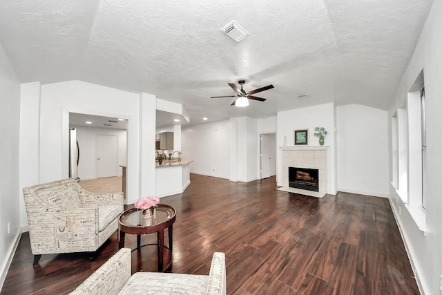 9223 Eaglewood Glen Trl, Houston, TX 77083 - living room with dark wood-type flooring, baseboards, a ceiling fan, a fireplace, and a textured ceiling