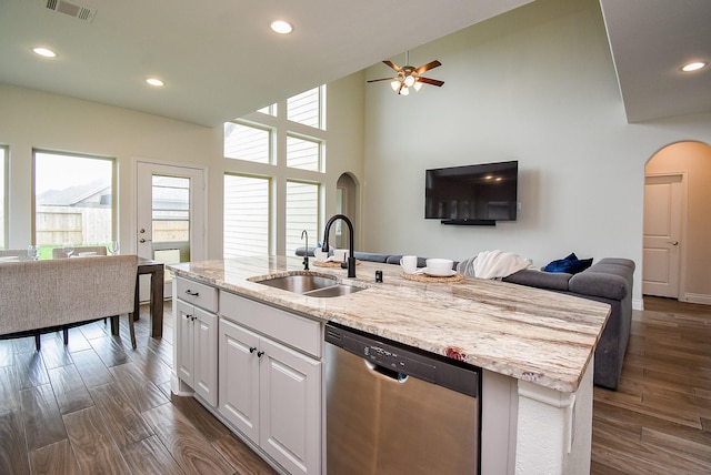 2804 Sable Creek Ln, Pearland, TX 77584 - kitchen featuring dishwasher, a sink, open floor plan, arched walkways, and white cabinetry
