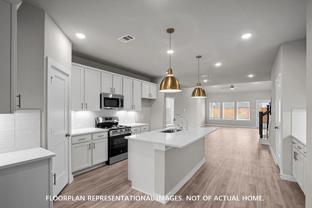 528 Flower Reed Ct, Magnolia, TX 77354 - kitchen with stainless steel appliances, a sink, light wood-type flooring, decorative backsplash, and recessed lighting