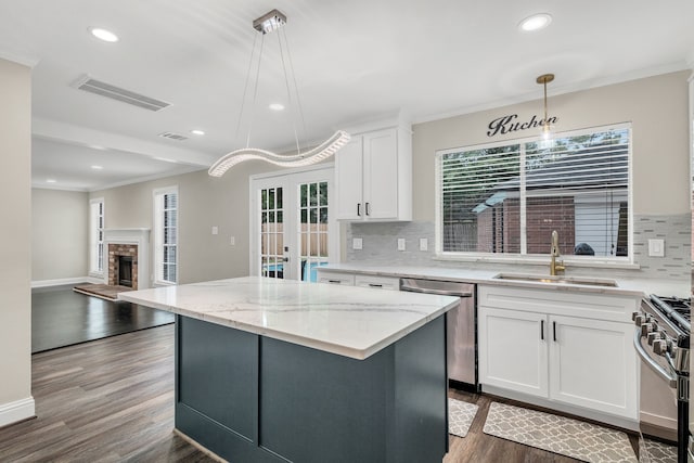 1118 Cheyenne Meadows Dr, Katy, TX 77450 - kitchen featuring a sink, appliances with stainless steel finishes, decorative backsplash, dark wood-type flooring, and a center island