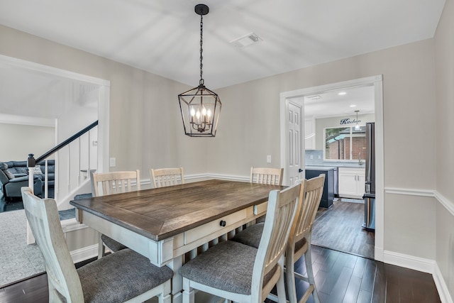 1118 Cheyenne Meadows Dr, Katy, TX 77450 - dining area with dark wood-style flooring, a chandelier, stairs, and baseboards