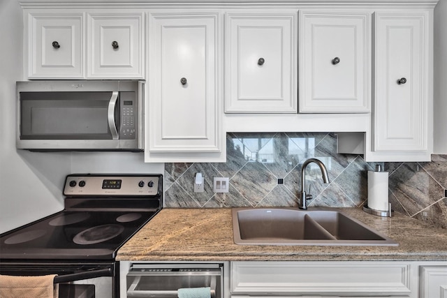 1401 E Beach Dr Unit 805/06, Galveston, TX 77550 - kitchen featuring stainless steel appliances, a sink, decorative backsplash, and white cabinetry