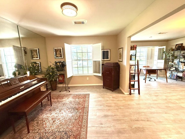 sitting room featuring healthy amount of natural light, baseboards, wood finished floors, and an office area