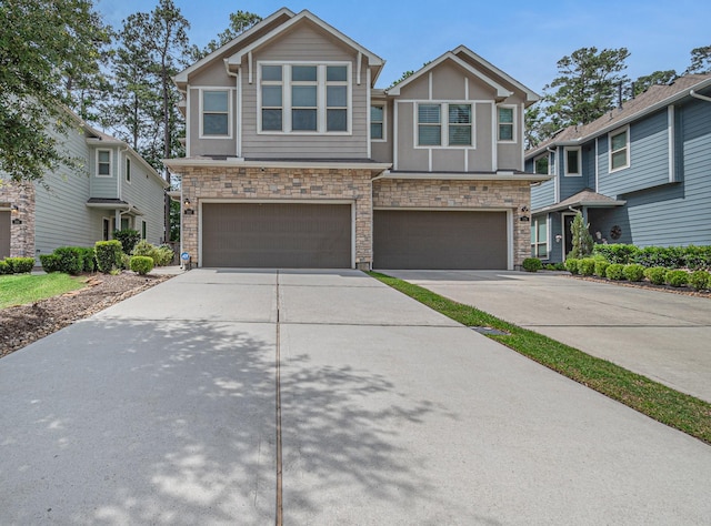 view of front of property featuring concrete driveway, stone siding, and an attached garage