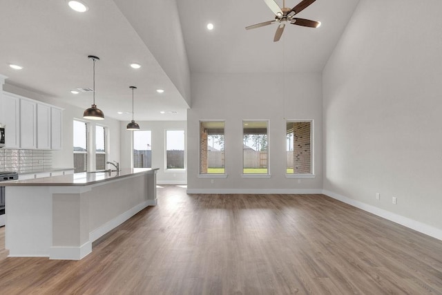 21611 Elmheart Dr, New Caney, TX 77357 - kitchen with stainless steel range with electric stovetop, recessed lighting, white cabinets, a ceiling fan, and light wood-type flooring