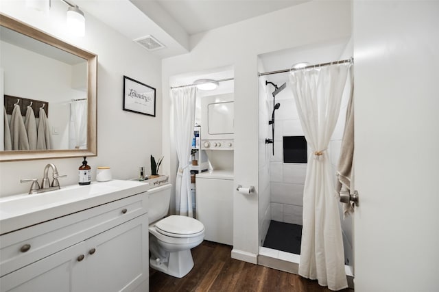 full bath with stacked washer / dryer, wood finished floors, a shower with shower curtain, toilet, and vanity