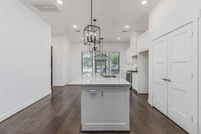 2305 Langston St, Houston, TX 77007 - kitchen featuring a sink, white cabinetry, a chandelier, stainless steel range with gas cooktop, and a center island with sink