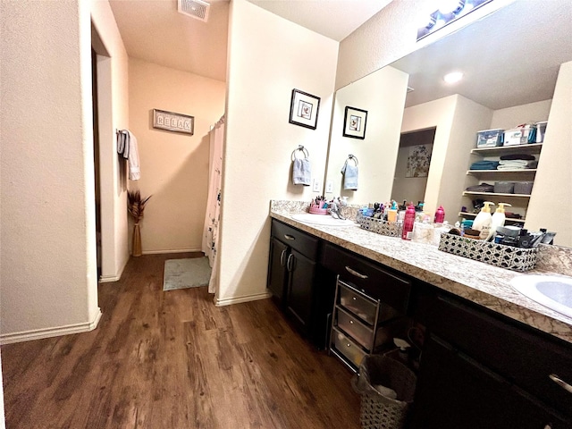 16410 Rodeo River Rd, Houston, TX 77049 - bathroom featuring wood finished floors, double vanity, and baseboards