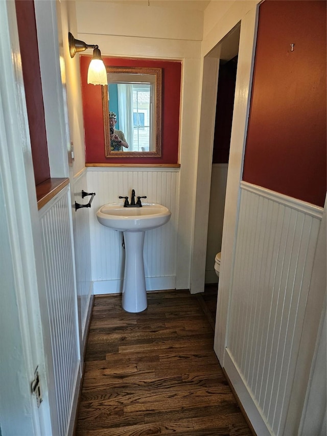 1316 Harvard St, Houston, TX 77008 - half bath featuring a wainscoted wall, wood finished floors, toilet, and a sink