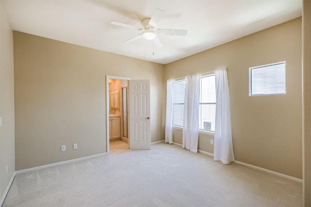701 Asbury St, Houston, TX 77007 - unfurnished bedroom featuring light colored carpet, baseboards, ensuite bath, and a ceiling fan