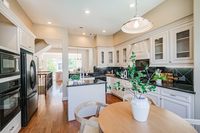 701 Asbury St, Houston, TX 77007 - kitchen with black appliances, dark countertops, hanging light fixtures, white cabinets, and recessed lighting
