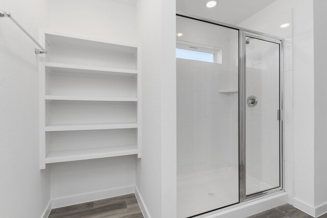 417 Amy St, Angleton, TX 77515 - bathroom featuring a stall shower, baseboards, wood finished floors, a spacious closet, and recessed lighting