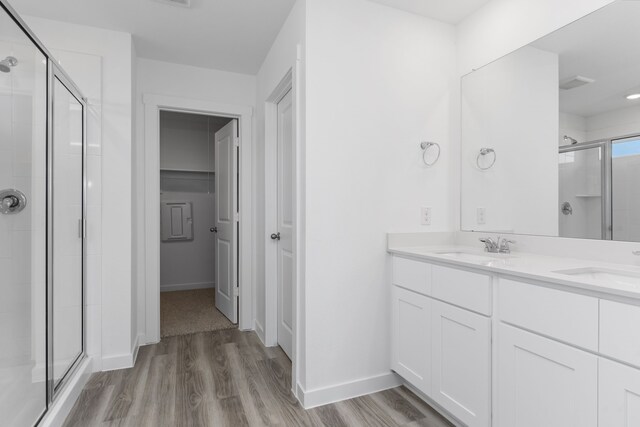 417 Amy St, Angleton, TX 77515 - bathroom with a stall shower, wood finished floors, double vanity, and baseboards