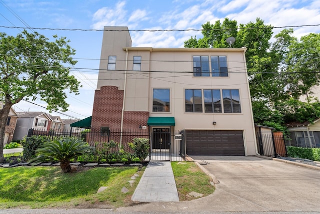 view of property with an attached garage, stucco siding, driveway, a fenced front yard, and a gate