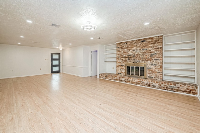 10806 Silkwood Dr, Houston, TX 77031 - unfurnished living room with a textured ceiling, built in shelves, wood finished floors, baseboards, and recessed lighting