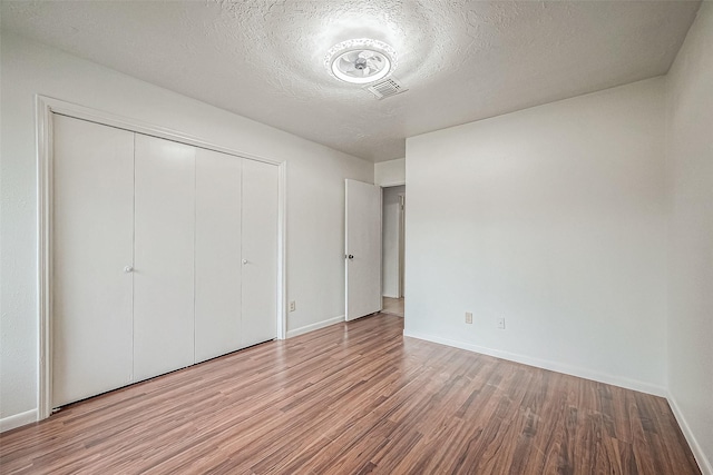 10806 Silkwood Dr, Houston, TX 77031 - unfurnished bedroom with wood finished floors, a closet, baseboards, and a textured ceiling