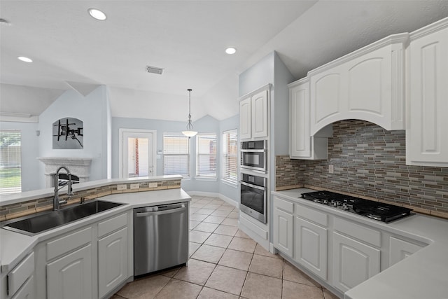 16503 Torry View Ter, Houston, TX 77095 - kitchen featuring appliances with stainless steel finishes, a sink, vaulted ceiling, decorative backsplash, and white cabinets