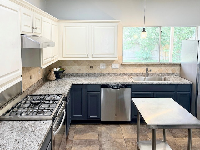 kitchen featuring a sink, under cabinet range hood, appliances with stainless steel finishes, and decorative backsplash