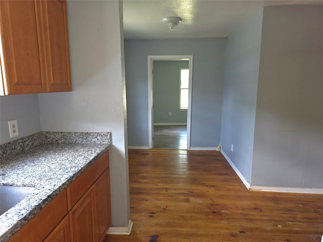 90 Oak Crest Dr, Shepherd, TX 77371 - kitchen with brown cabinetry, wood finished floors, baseboards, and a sink