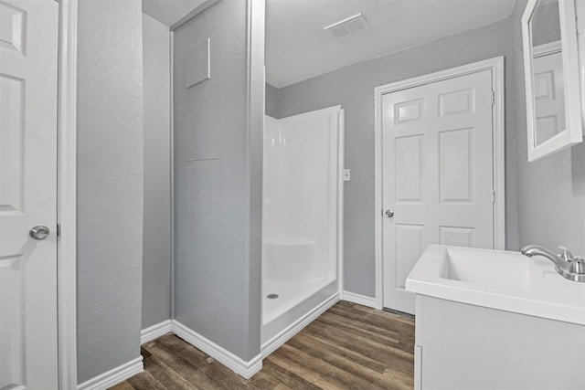90 Oak Crest Dr, Shepherd, TX 77371 - bathroom featuring wood finished floors, a shower stall, baseboards, and vanity