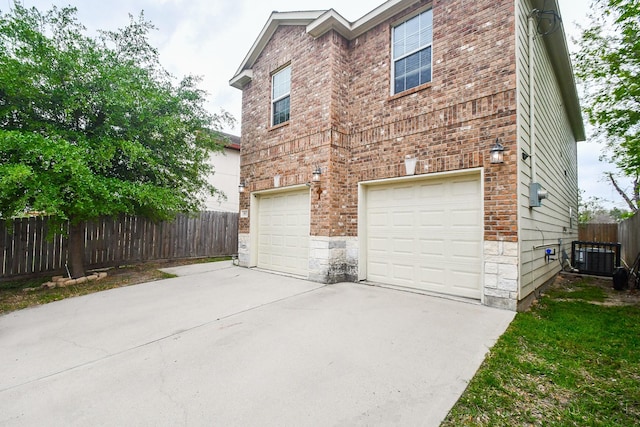 4915 Market St, Houston, TX 77020 - view of home's exterior featuring a garage, concrete driveway, fence, cooling unit, and brick siding