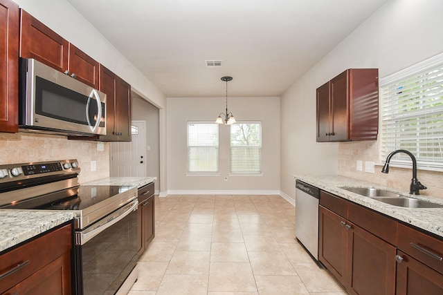 4915 Market St, Houston, TX 77020 - kitchen with stainless steel appliances, a sink, baseboards, decorative backsplash, and a chandelier