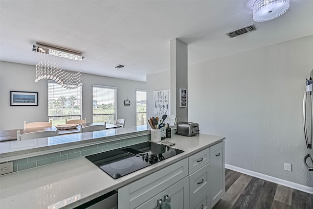 8111 Broadway St Unit 7, Galveston, TX 77554 - kitchen with black electric cooktop, dark wood-style floors, light stone countertops, and baseboards