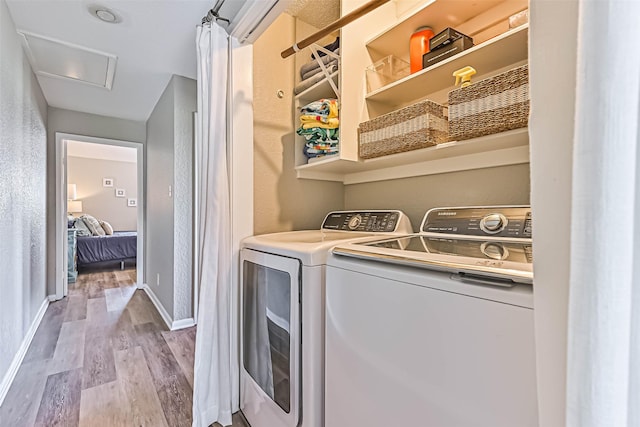 8111 Broadway St Unit 7, Galveston, TX 77554 - laundry area featuring washing machine and clothes dryer, wood finished floors, baseboards, and attic access